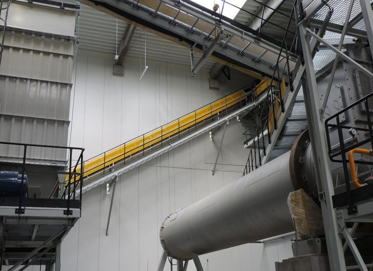 Transport surowców za pomocą przenośnika taśmowego w instalacji przemysłowej